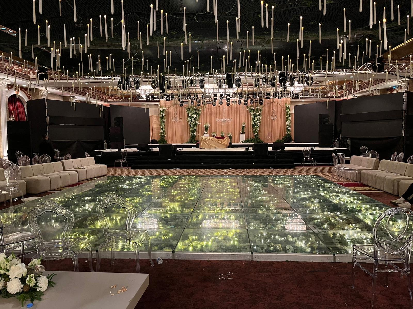 Antalya düğün organizasyonu için çiçek süslemeli şeffaf cam podyum ve ışıklı dans pisti kurulumu